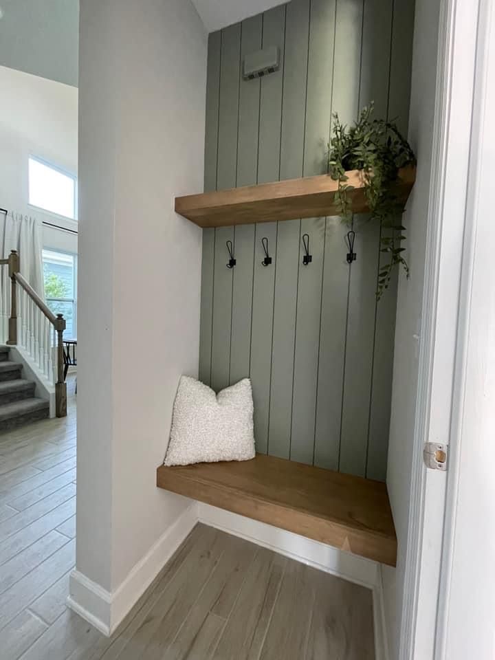 a wooden bench sitting in the corner of a room next to a door and stairs