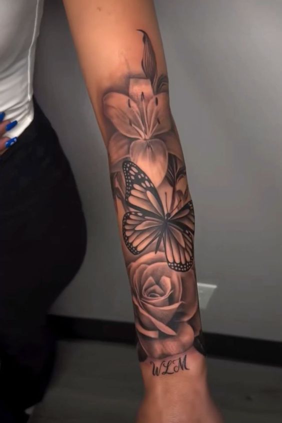 a woman's arm with flowers and a butterfly on it