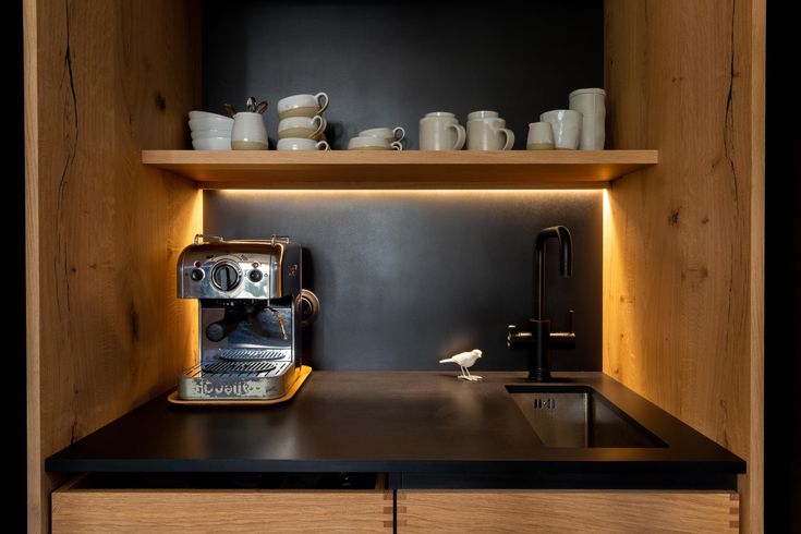 an espresso machine sitting on top of a counter next to a wooden shelf