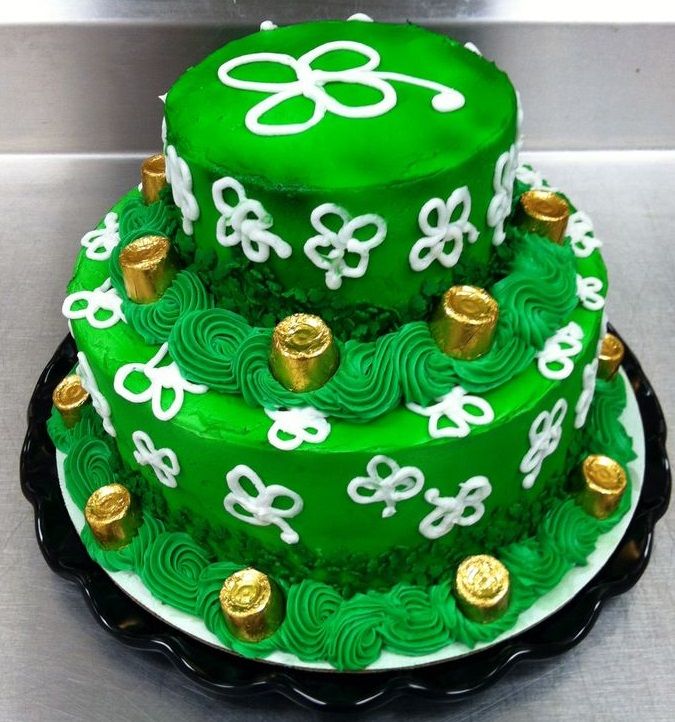 a three layer green cake with gold decorations