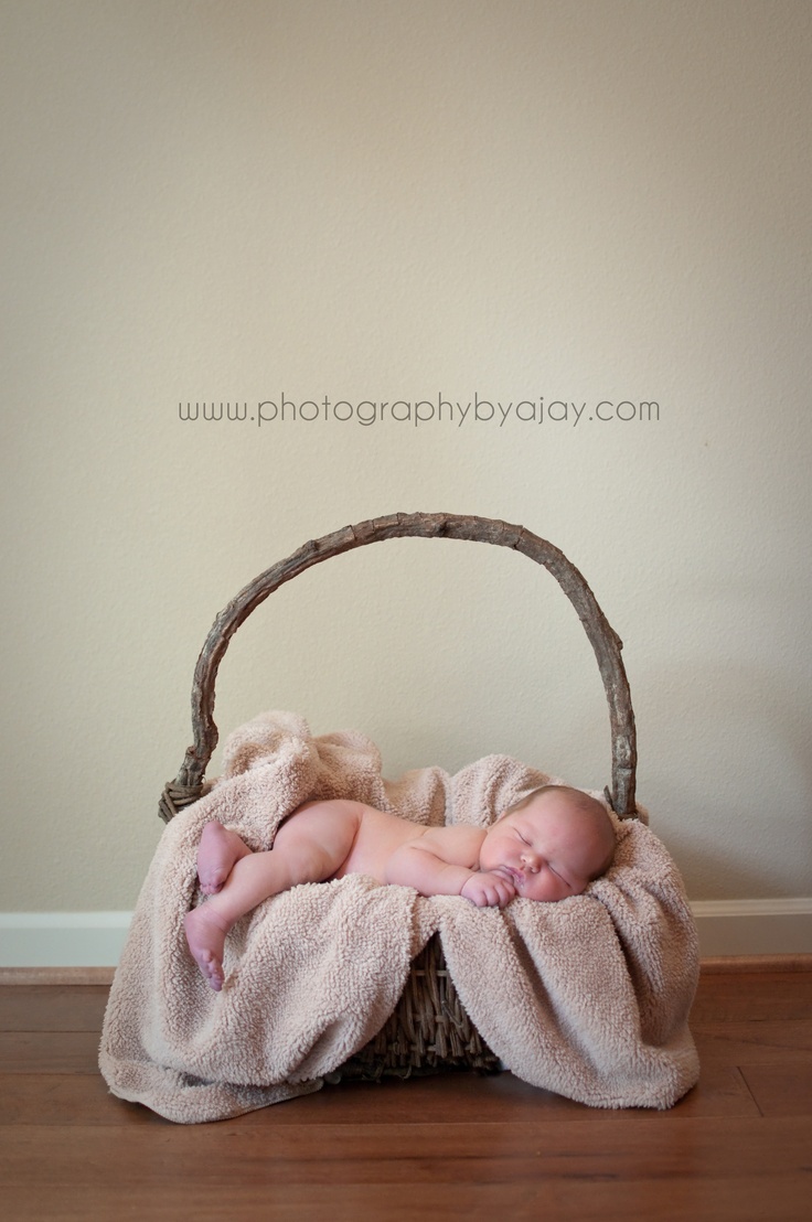 a baby is sleeping in a basket with a blanket over it's head and body