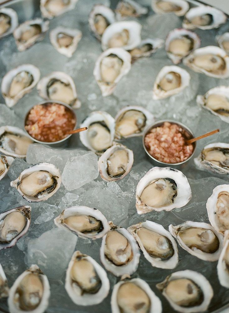 oysters on ice with dipping sauce in bowls