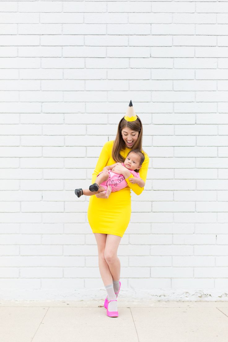 a woman in a yellow dress holding a baby