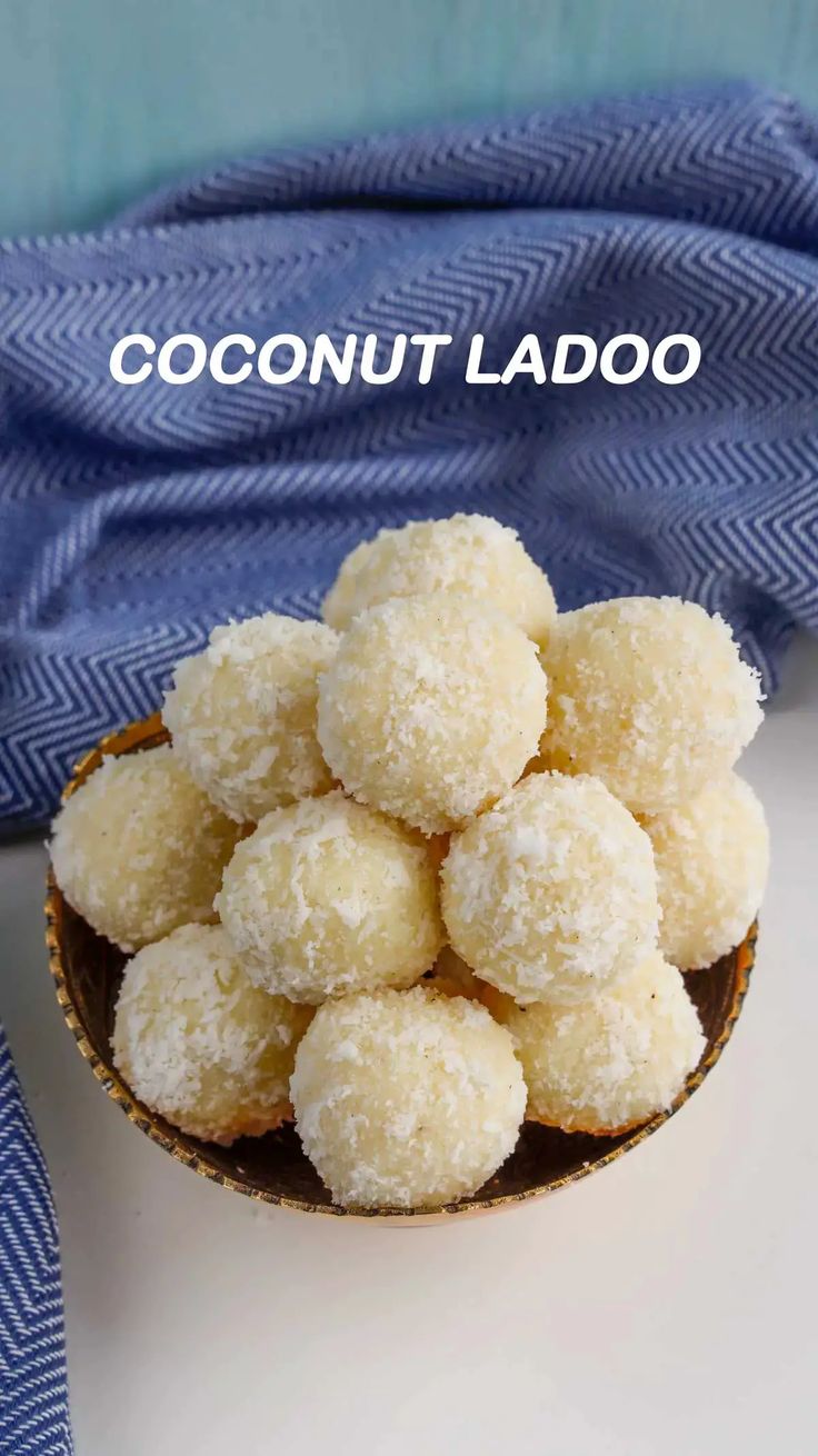 coconut ladoo in a small bowl on a white surface with the words coconut ladoo above it