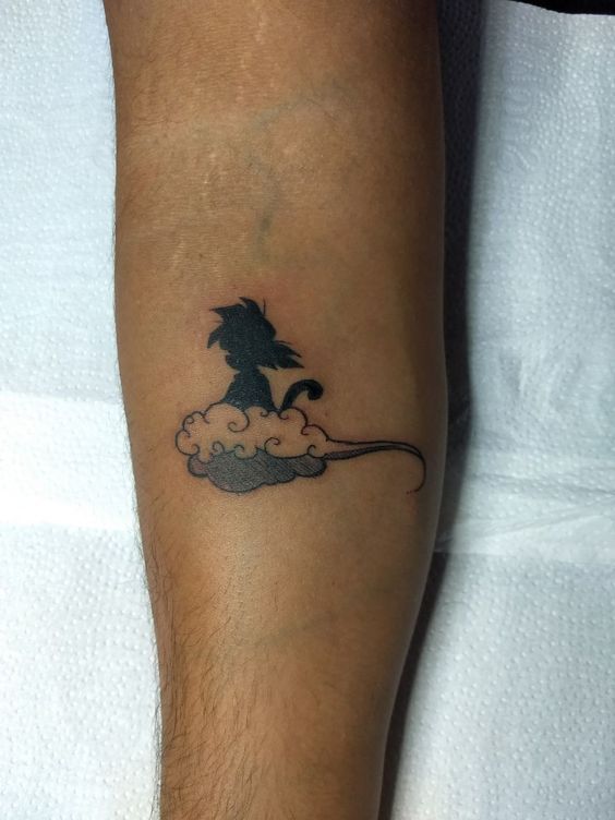 a person with a small tattoo on their leg that has a black and white image of a wizard flying in the sky