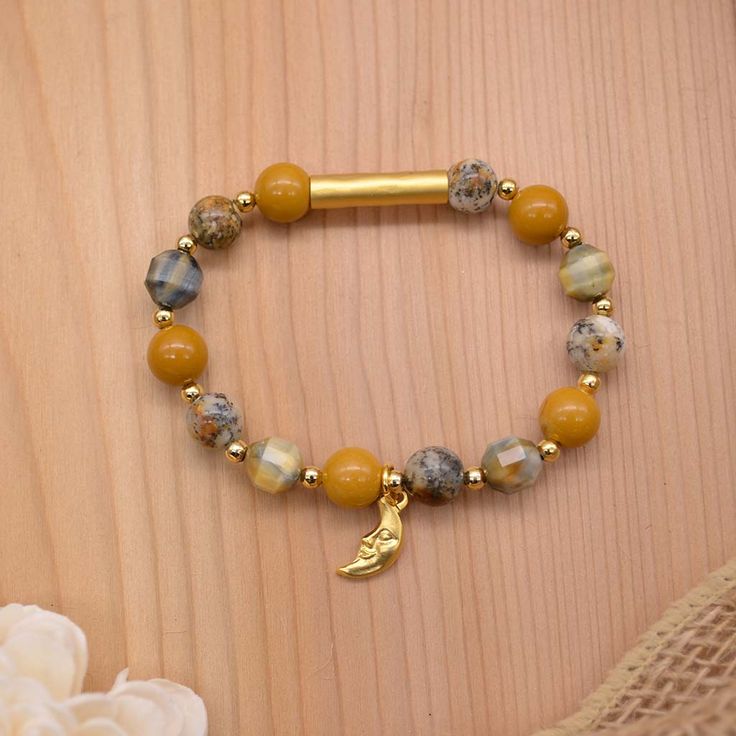 Our mystic DayDream Bracelet is created with bright and bold mookaite stones, natural African dendritic opal, faceted blue blonde tigers eye, a 22k matte gold plated focal bar, and a 22k matte gold plated smiling crescent moon charm. Lose yourself in deep thought with our DayDream Bracelet. Experience a little bit of nature with every Emerald Sun Creations!Wear suggestions: Wear to add a little sparkle or pop of color to any fit, wear everyday for a little elegant mystery, or stack this bracelet Gold Beaded Bracelet With Natural Stones For Meditation, Gold Beaded Bracelets With Natural Stones For Meditation, Gold Agate Beaded Bracelets With Gemstones, Handmade Gold Stretch Bracelet For Meditation, Gold Beaded Bracelets With Natural Stones For Healing, Gold Bracelets With Agate And Natural Stones, Gold Stretch Bracelet With Natural Stones For Meditation, Gold Gemstone Stretch Bracelet Ideal For Gift, Gold Gemstone Stretch Bracelet As Gift