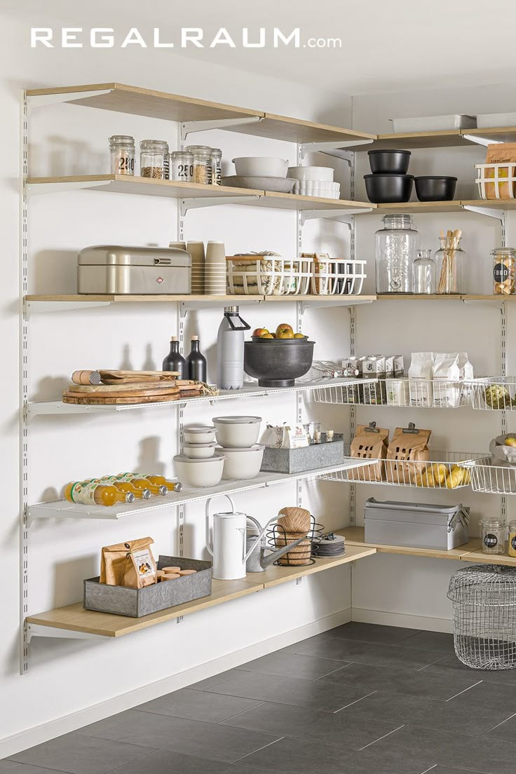 an organized pantry with lots of food in baskets and containers on shelving units, along with other kitchen items