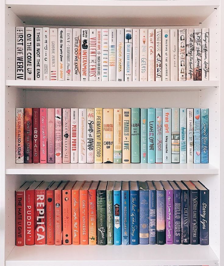 a book shelf filled with lots of different colored books on top of eachother