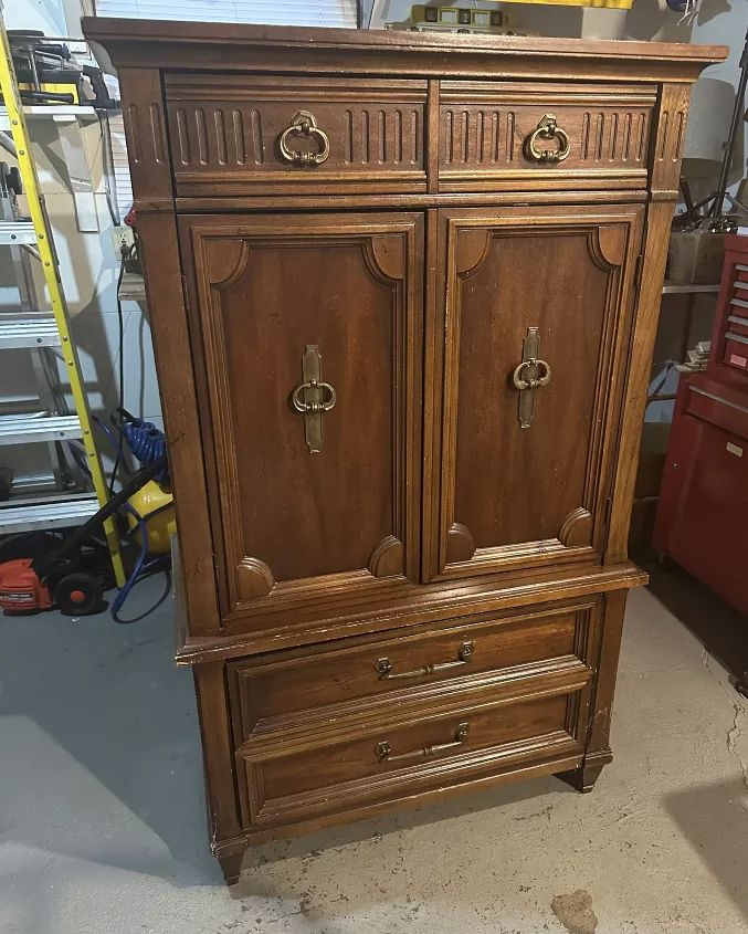 an old wooden armoire in a garage