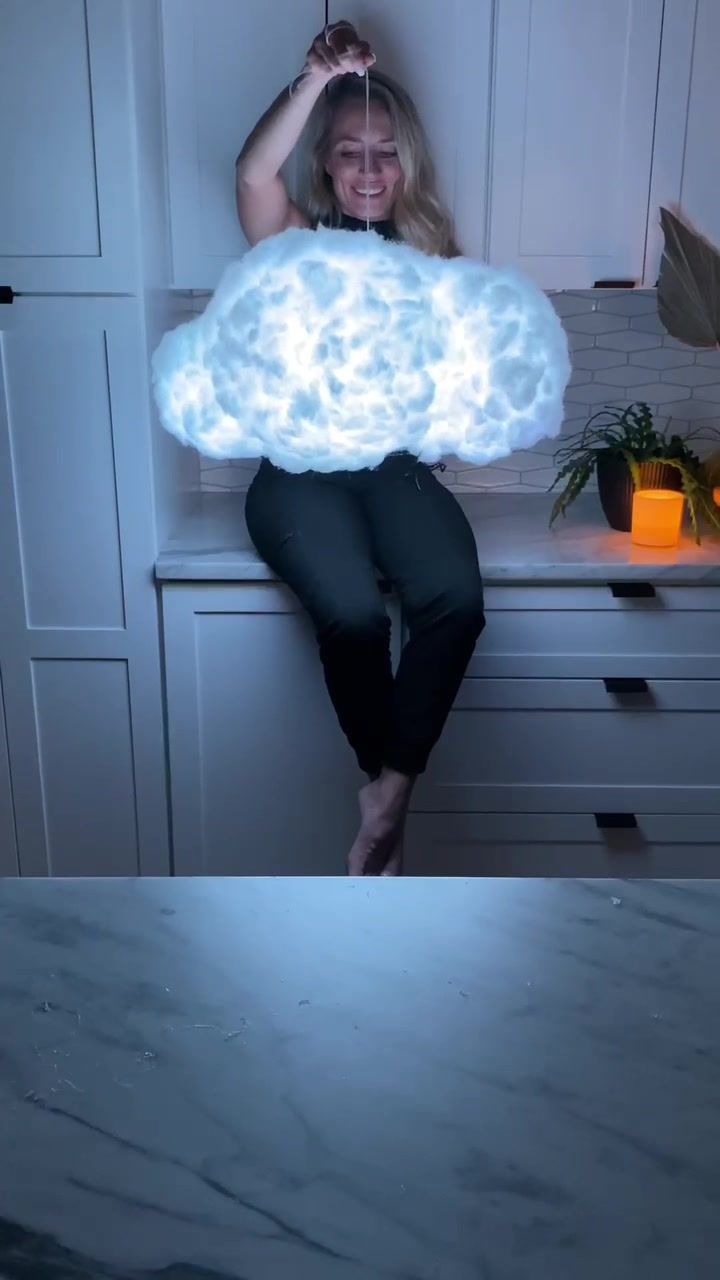 a woman sitting on top of a counter with a cloud above her head