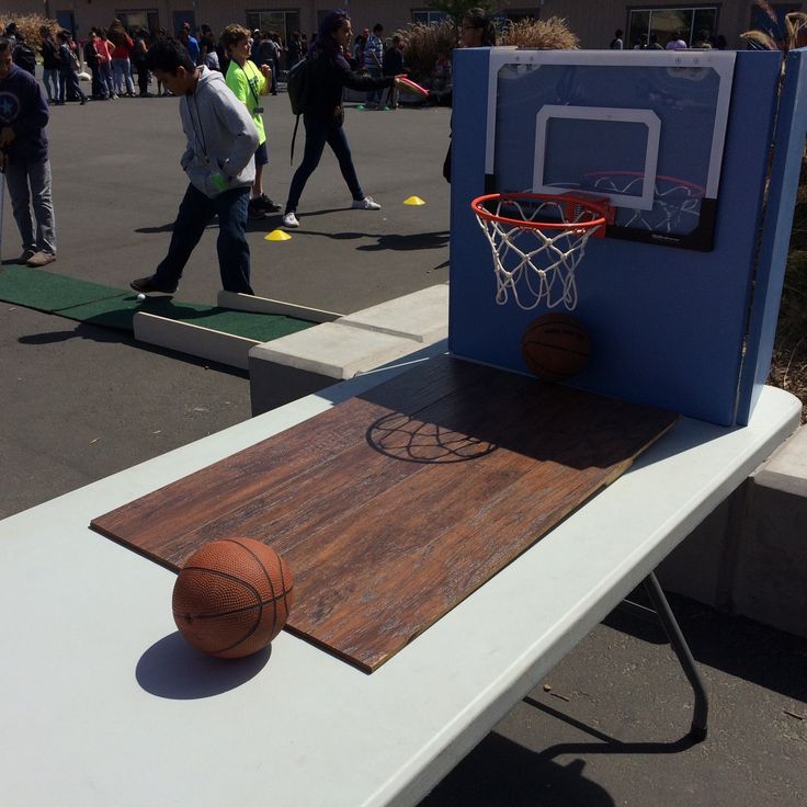 an outdoor basketball court with people walking around it