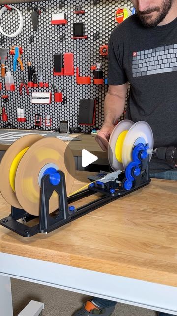 a man is working on some type of machine in his shop with two spools