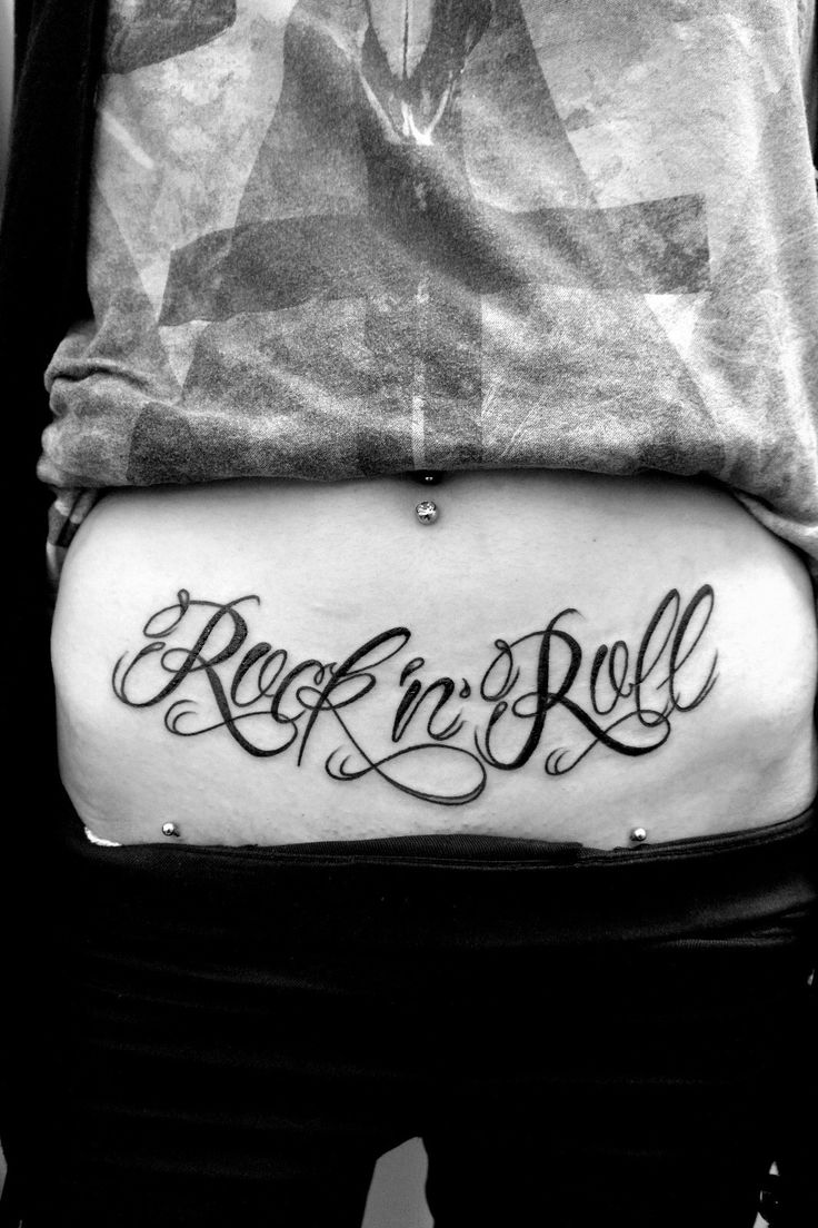 the back of a woman's stomach that says rock n roll and is written in cursive font