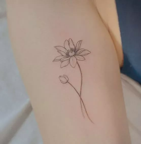 a single flower tattoo on the left side of the arm is shown in black and white