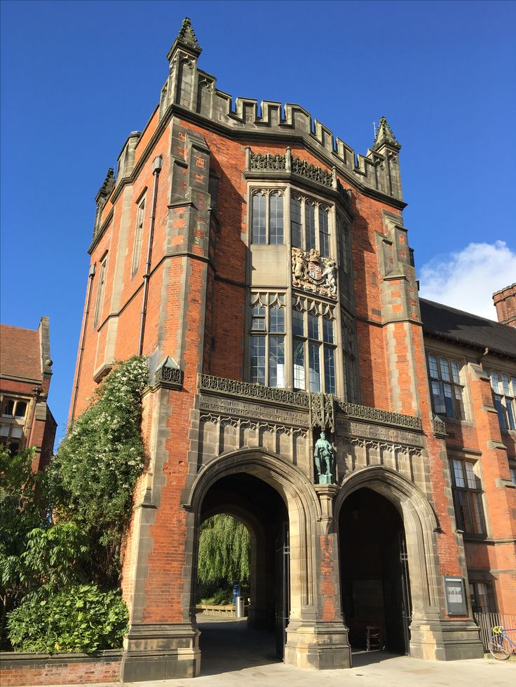 an old brick building with a clock on it's face and arched doorways