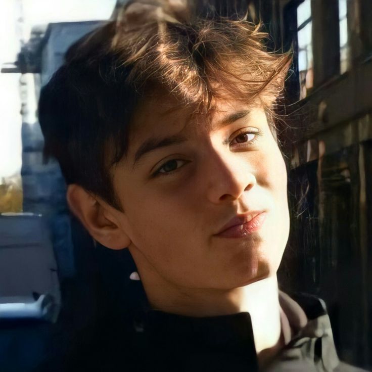 a young man standing in front of a building