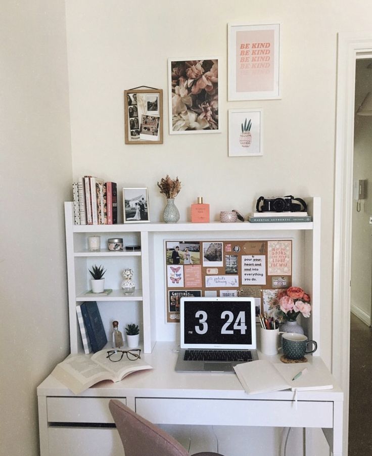 a white desk topped with a laptop computer next to a book shelf filled with books