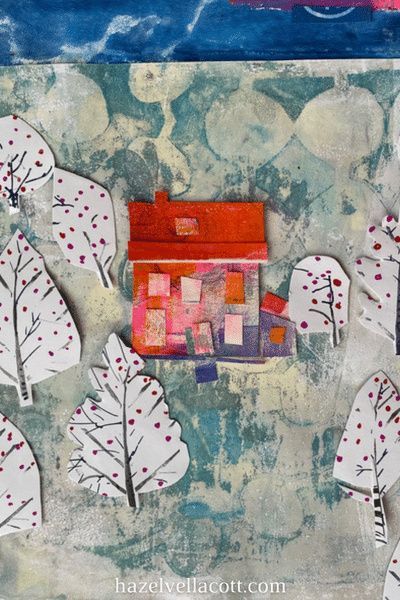 an art project with paper cut out of trees and houses in the background, including one red house