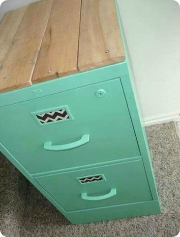 a green filing cabinet sitting on top of a carpeted floor