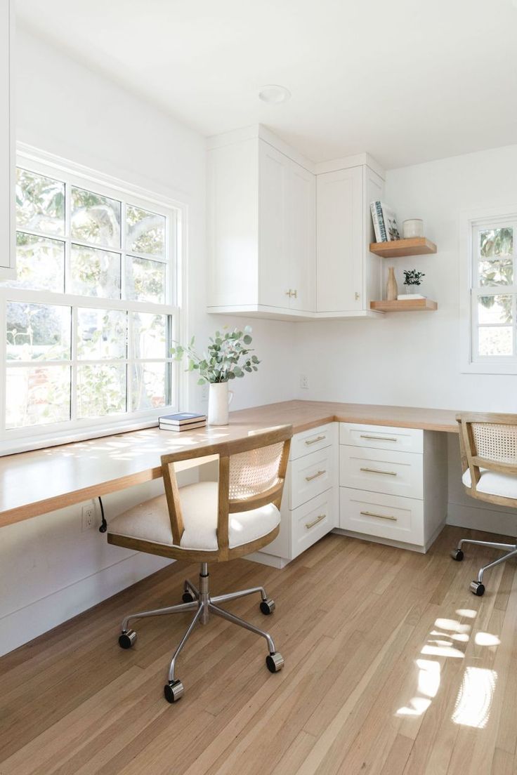 a home office with white cabinets and wood floors