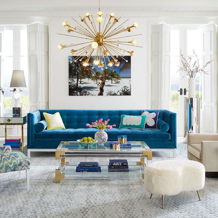 a living room filled with furniture and a chandelier hanging over the top of it