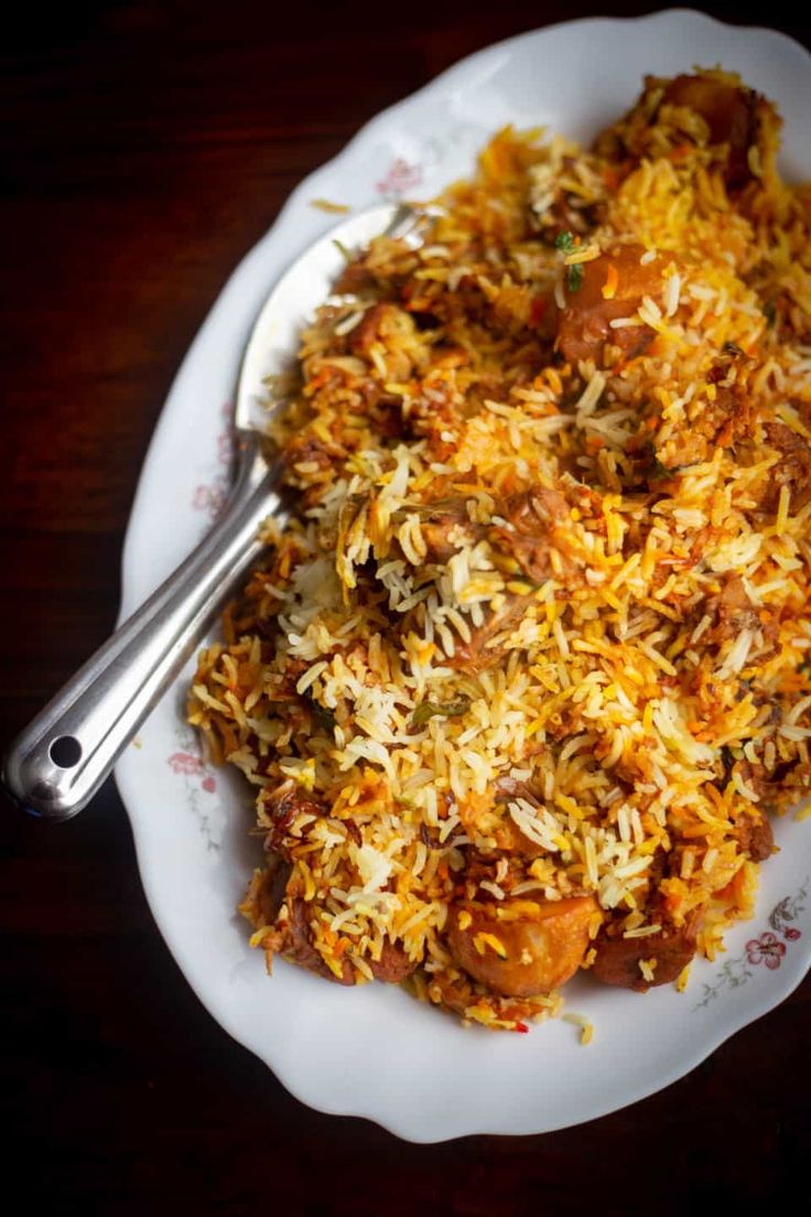 a white plate topped with rice and meat