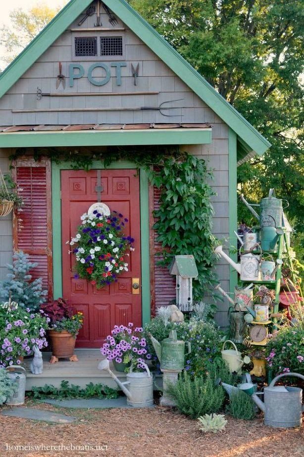 a red door surrounded by potted plants and flowers