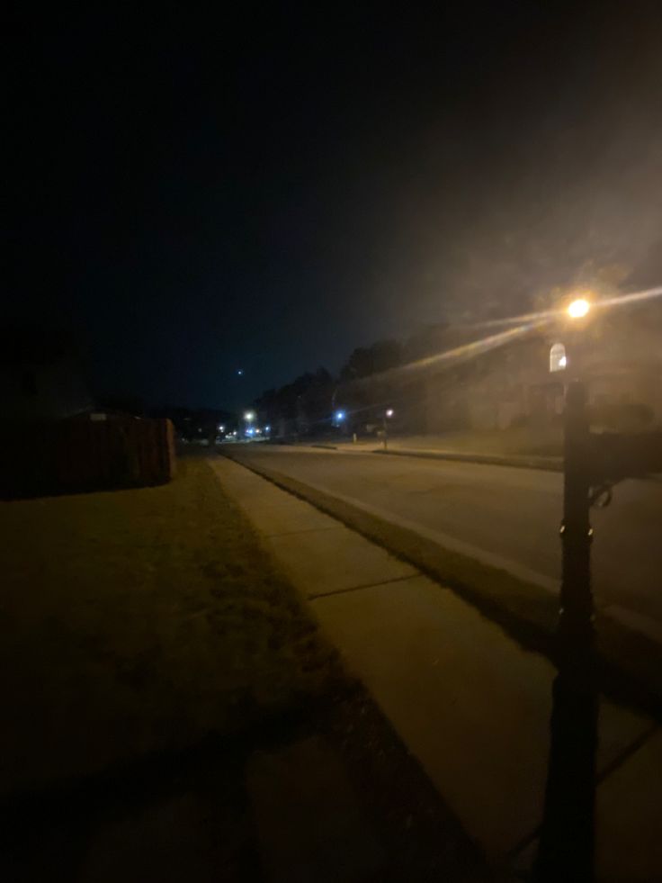 the fog is coming down on the street at night