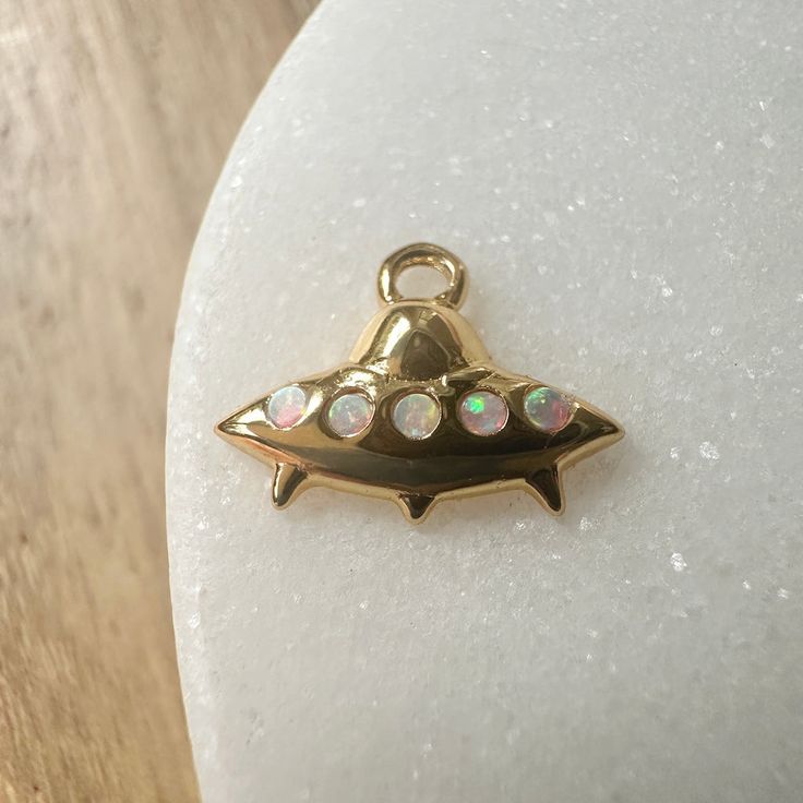 Whether you're a 👽 believer or not, this mini mothership charm is too cute to pass up. Wear it on it's own or on a jumble alongside your favorite charms on a necklace, bracelet, or strung upon hoops. Charm measures 6mm x 12mm. Simulated opal. Comes with a removable oval jump ring. Our materials make for an amazing, high quality, seamless, jewelry piece with longevity. Our rings are plated with 18k gold, 18k rose gold, or sterling silver and finished with a protective coating. A little secret we Dainty Charms With Lobster Clasp For Gifts, Small Charms Jewelry For Gifts, Small Charms Jewelry As A Gift, Spiritual Dangling Charms For Gifts, Small Charm Necklaces For Gifts, Unique Adjustable Charm Necklaces, Dainty Small Charms Jewelry, Small Dainty Charms Jewelry, Adjustable Dangle Charms For Everyday