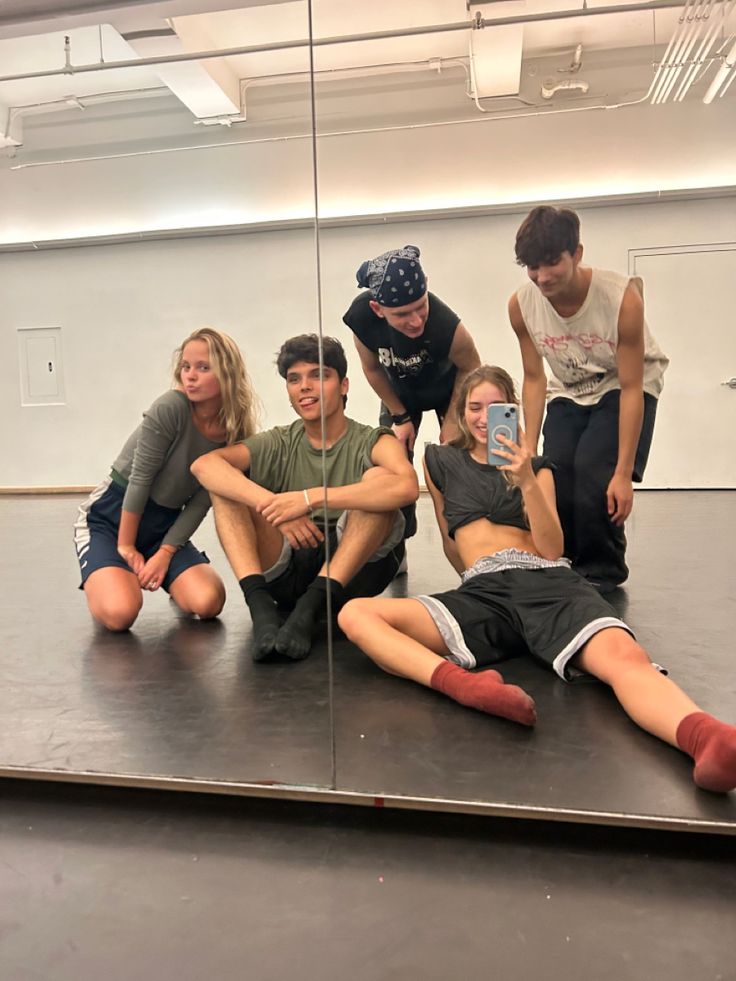 a group of young people sitting on top of a floor