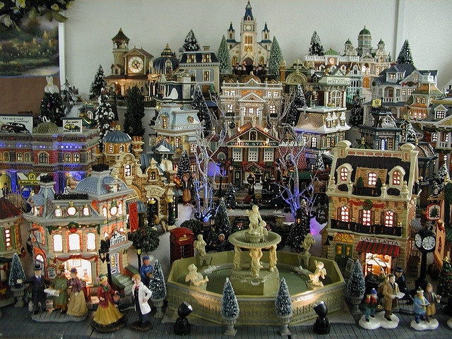 an assortment of christmas village figurines on display