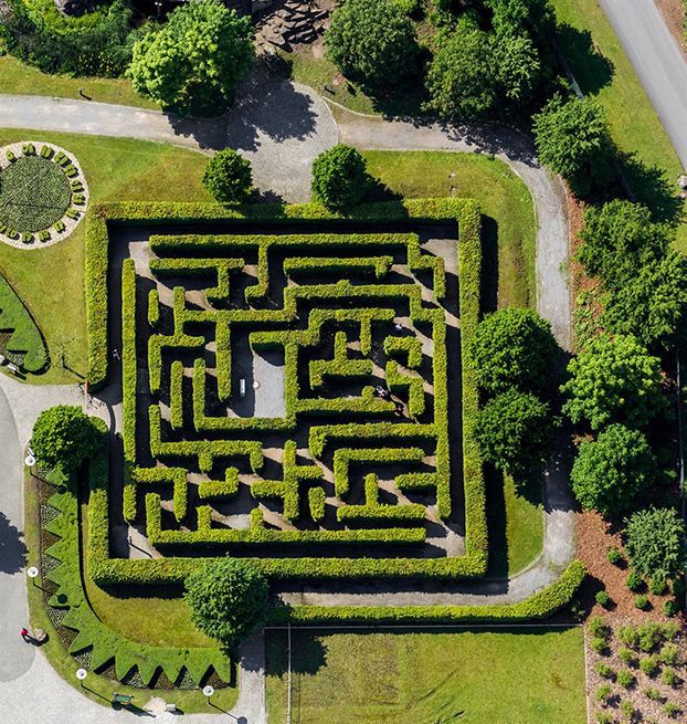 an aerial view of a maze in the middle of a park