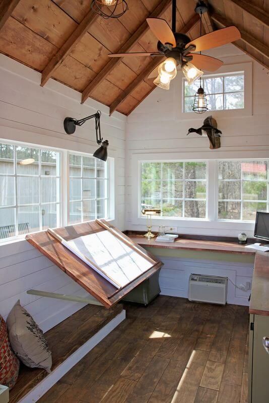 a kitchen with wood flooring and ceiling fan mounted to it's side wall