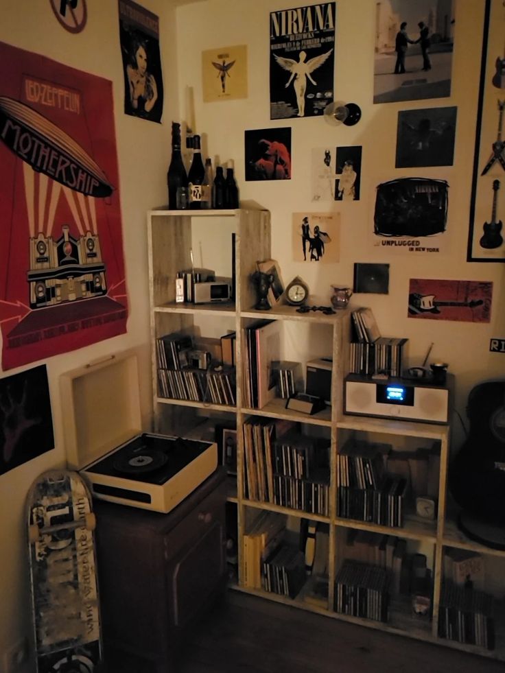 a room filled with lots of musical equipment and pictures on the wall next to bookshelves