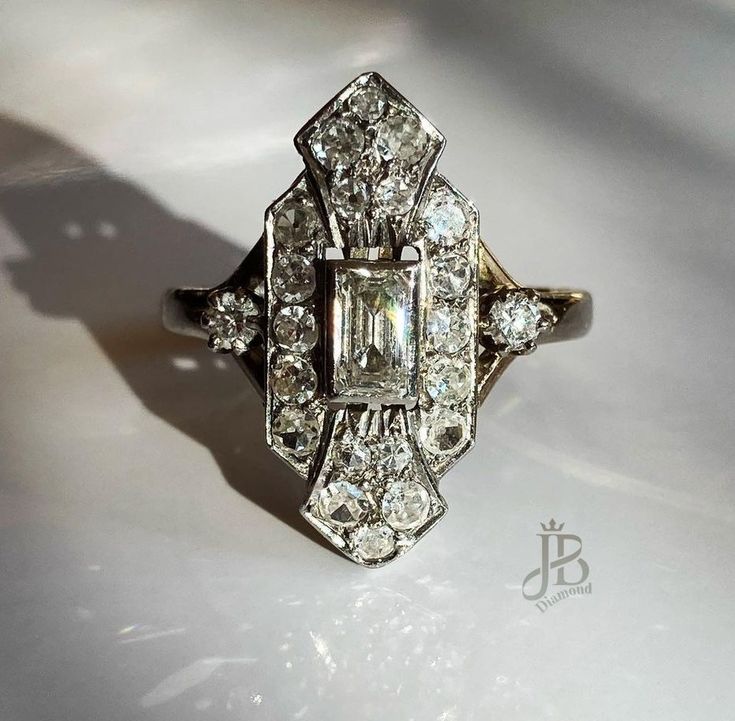 an antique diamond ring is displayed on a white surface