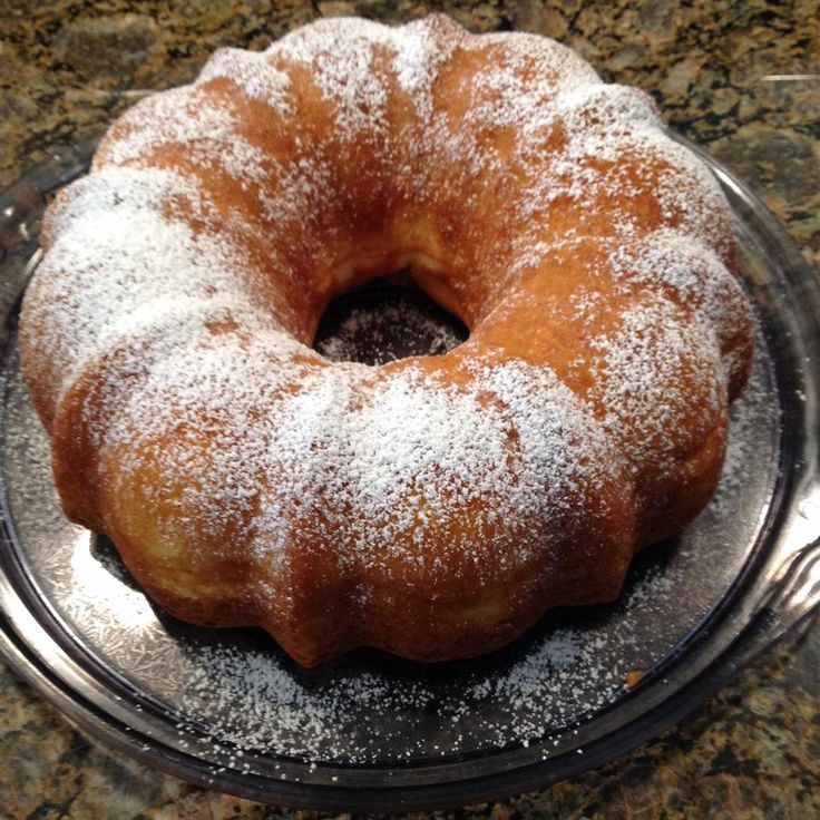 a powdered sugar covered donut sitting on top of a cake plate