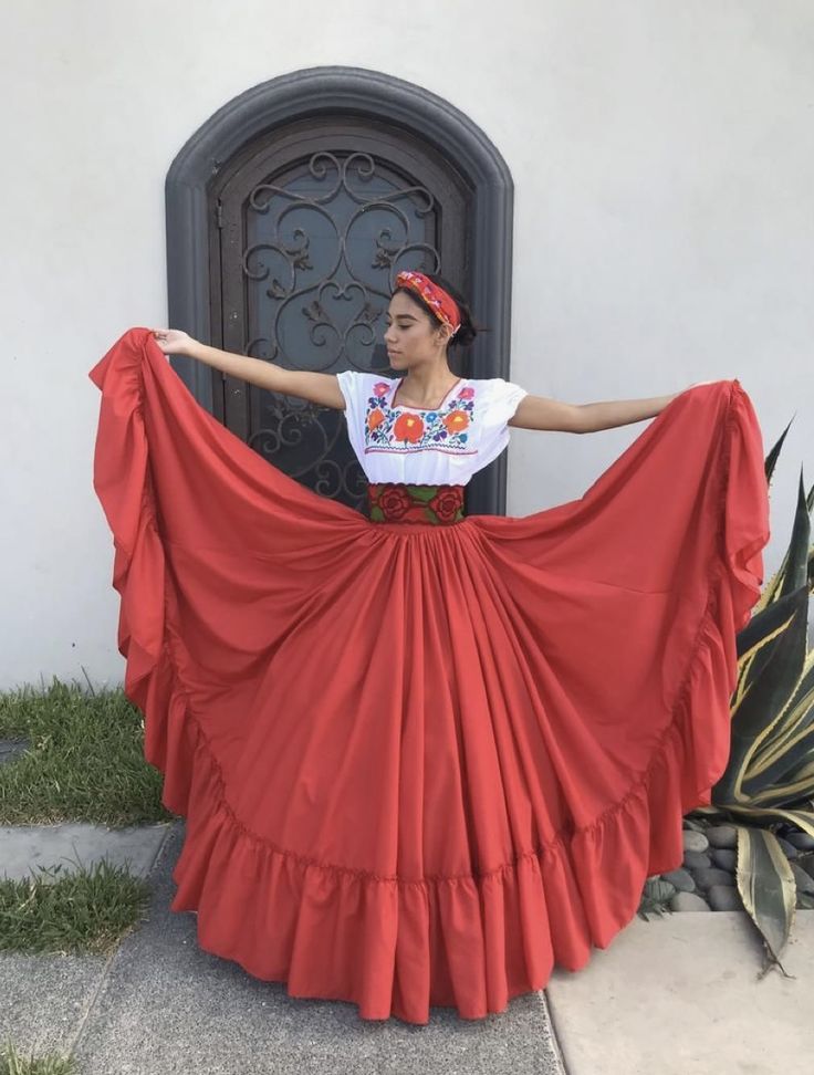 a woman in a red skirt is posing for the camera