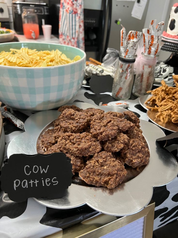 a table topped with plates filled with cookies and other food next to a bowl of macaroni and cheese