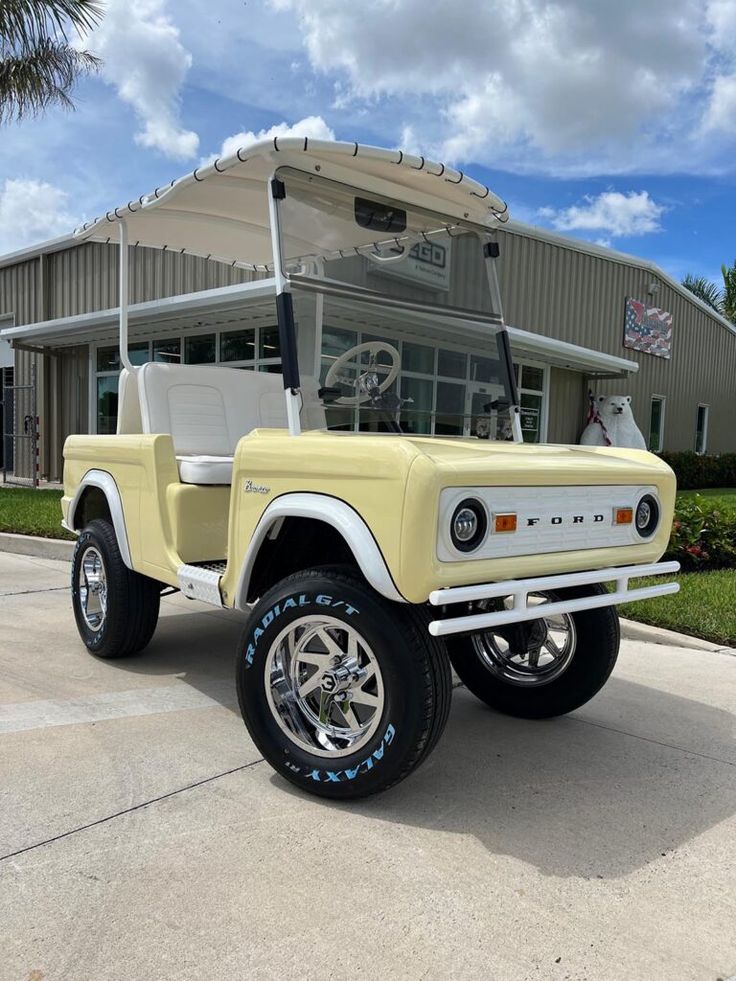 a yellow jeep parked in front of a building