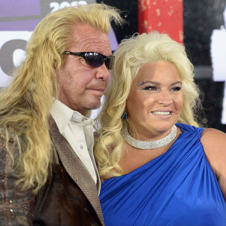 a man and woman dressed in formal wear posing for the camera on the red carpet