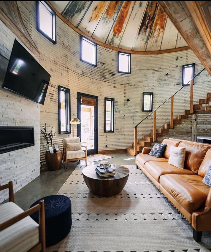 a living room filled with furniture and a flat screen tv mounted to the side of a wall