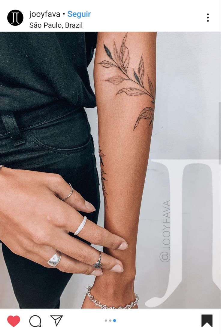 two people are holding hands with tattoos on their arms and one is wearing a ring