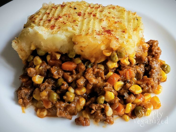 a white plate topped with mashed potatoes, corn and ground beef covered in gravy