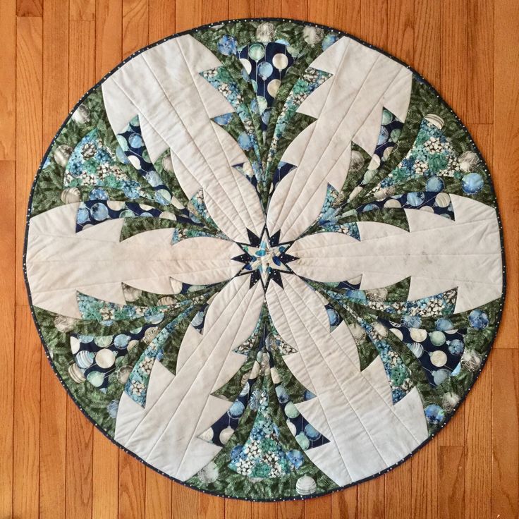 a close up of a circular quilt on a wooden floor