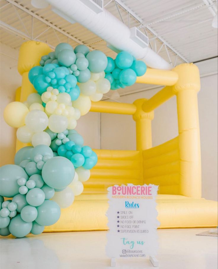 an inflatable arch with balloons on it and a sign that says b - buncere