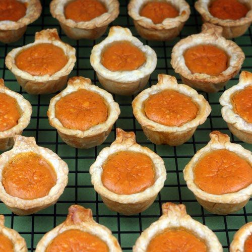 many small pies are sitting on a cooling rack