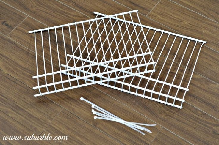 three white wire baskets sitting on top of a wooden floor next to scissors and toothbrushes