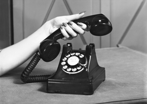 a woman's hand on an old fashioned telephone