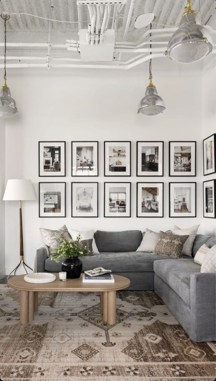 a living room filled with furniture and framed pictures on the wall above an l - shaped couch