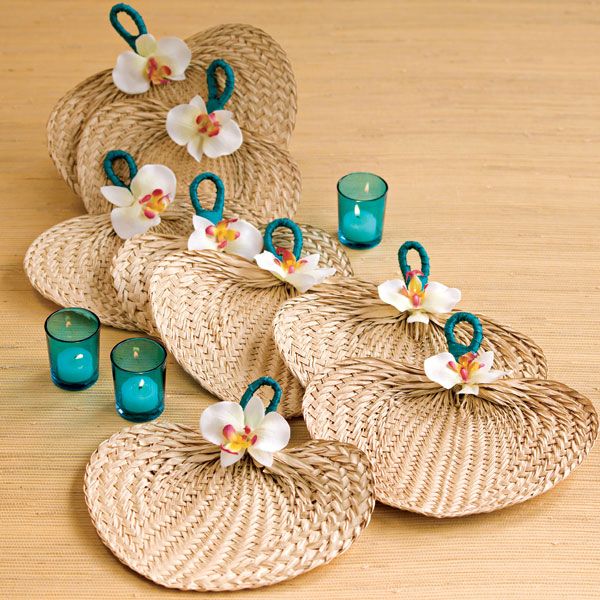 several wicker baskets with flowers and candles on top of a wooden table next to two tea lights